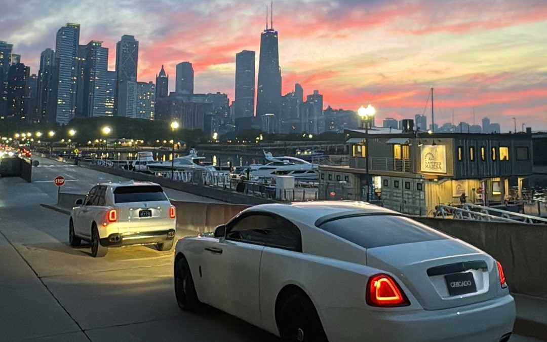 White Rolls-Royce Wraith rental with the Chicago skyline at sunset